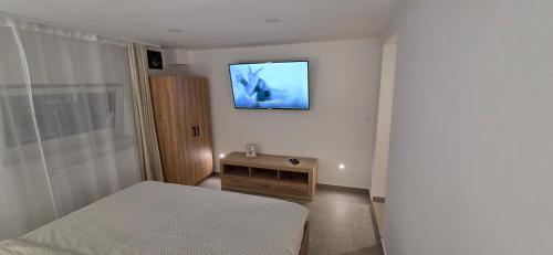 a bedroom with a bed and a television on the wall at Melody Apartment Kutina in Kutina