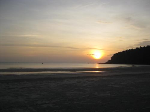a sunset on the beach with the sun setting at Frog Garden Hut in Ko Phayam