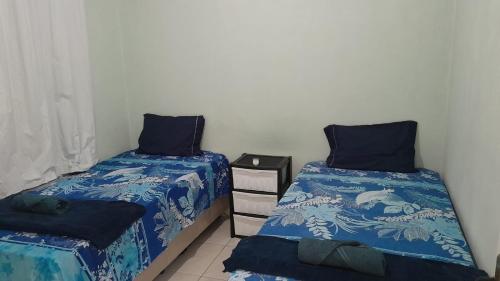 a bedroom with two beds with blue comforters at CASAS com PISCINA SENSACIONAIS NO CENTRO - Residencial Tchê in Barreirinhas