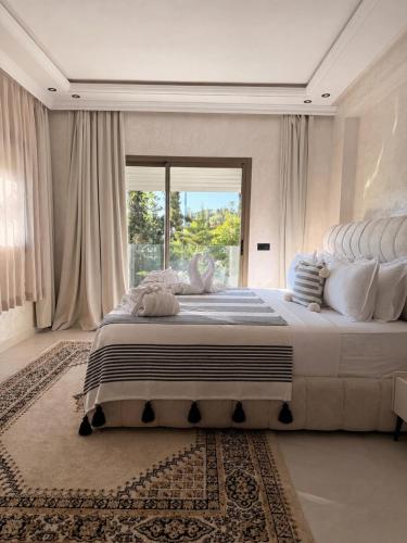 a bedroom with a large bed with a large window at Riad Villa Elizabeth in Nouaseur