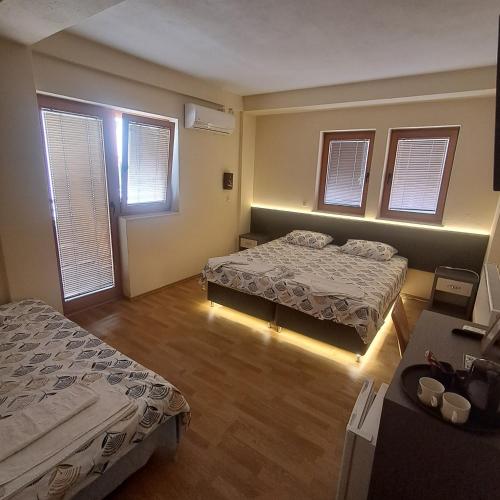 a room with two beds and two windows at Villa Rimari in Ohrid