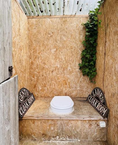 a bathroom with a toilet in a wooden wall at Harbour view Tree House in Cobh