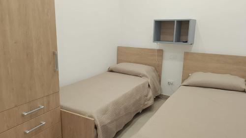 a small room with two beds and a window at House Mare Blu in Balestrate
