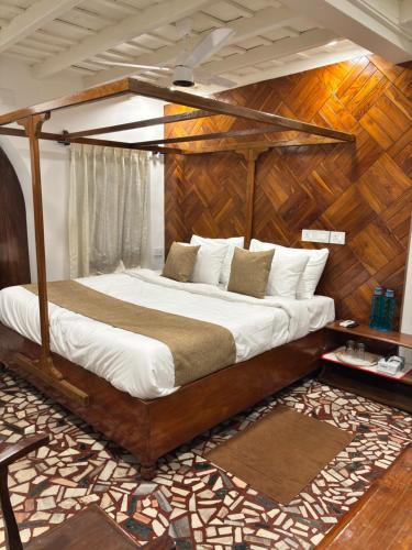a bedroom with a bed with a wooden headboard at Chettiparambil Heritage in Cochin