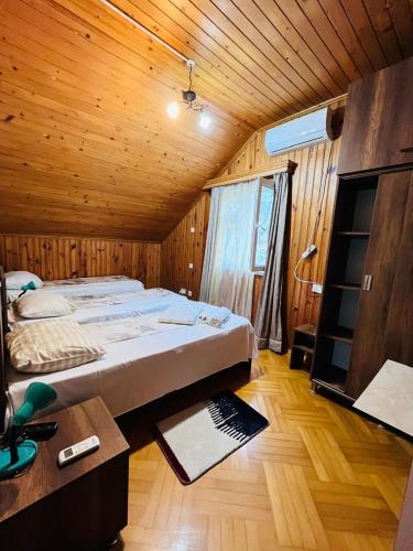 a bedroom with a large bed in a wooden room at Dato's GuestHouse in Makhinjauri