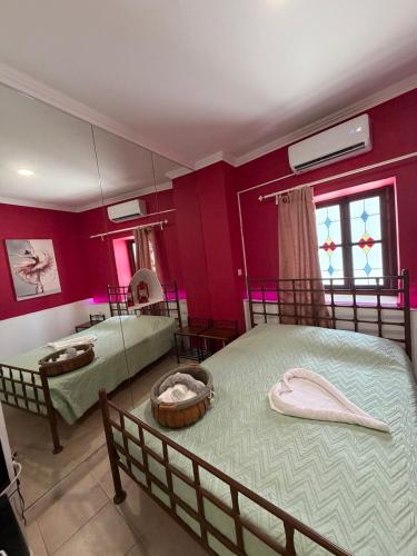 two beds in a room with red walls at Esperando in Maroni