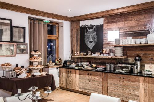 a kitchen with wooden walls and a counter with food at Hotel Christiania in La Clusaz