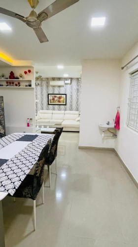 a living room with a table and chairs and a couch at Blue Breeze Villa in Mahabalipuram