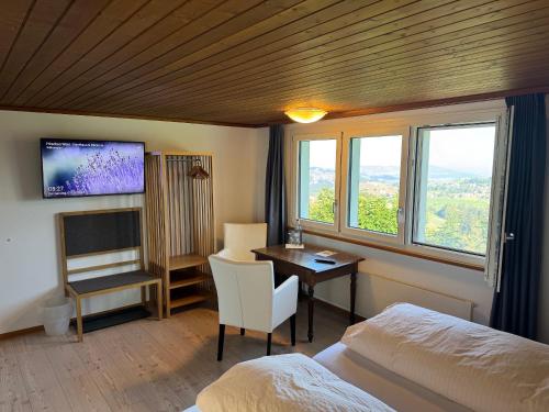 a bedroom with a bed and a desk with a tv at Hirschen Wald - Gasthaus & Bäckerei in Wald