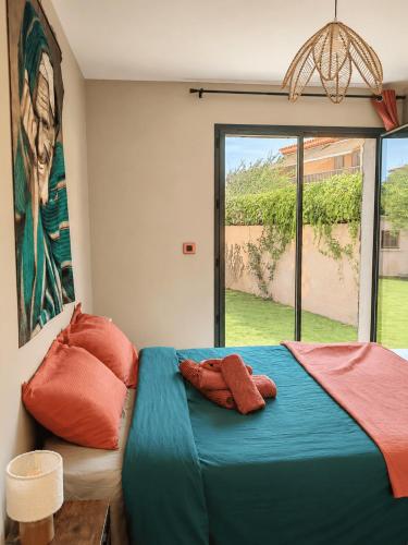a bedroom with a bed with two pillows and a window at Villa Mezzanotte Le Brusc 80m de la mer - Climatisation-Piscine-Parking in Six-Fours-les-Plages