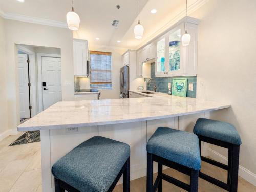a kitchen with a large counter with two stools at Old Marco Inne 403 in Marco Island