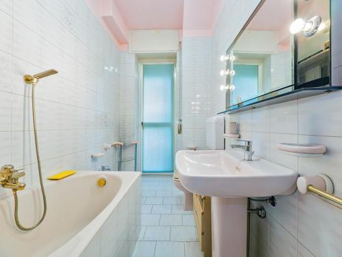 a white bathroom with a sink and a bath tub at La Dolce vista, Lecco apartment with lake view in Malgrate