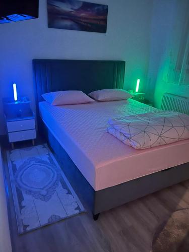 a bedroom with a bed with blue and green lights at Stan Krndija - Tesanj in Tešanj