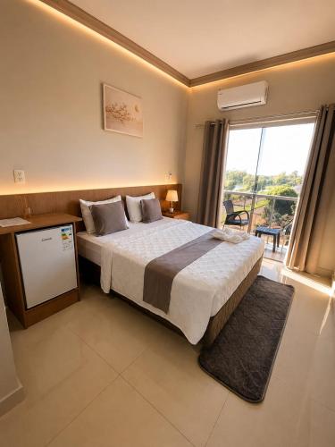 a bedroom with a large bed and a large window at Hotel Diromani in Hernandarias