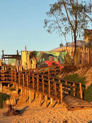a mural of a man sitting on a fence at Graffi Beach House in Florianópolis