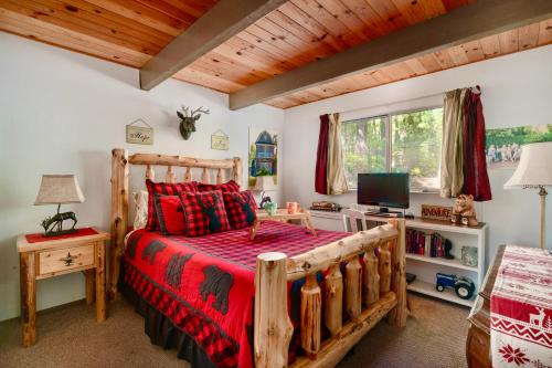 a bedroom with a wooden bed with red pillows at Cozy Cabin - Hot Tub, Fire Pit, & Pets in Arnold