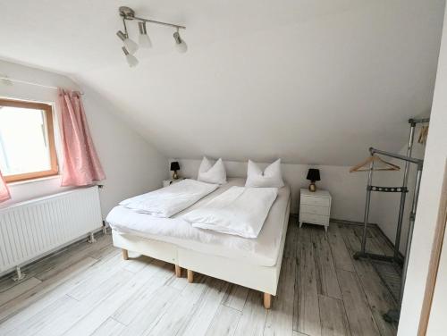 a bedroom with a white bed in a attic at Appartement am Bach in Bad Berneck im Fichtelgebirge