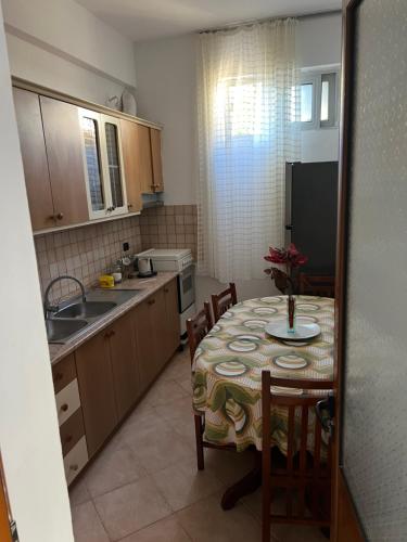 a kitchen with a table with chairs and a refrigerator at Eljo Apartment in Asim Zeneli