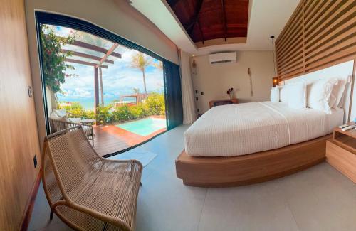 a bedroom with a bed and a view of a pool at Poozendin Hotel de Charme in Canoa Quebrada