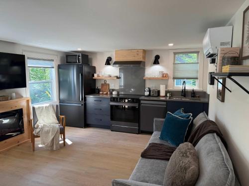 a living room with a couch and a kitchen at Sunapee Getaway With Lake Access in Sunapee