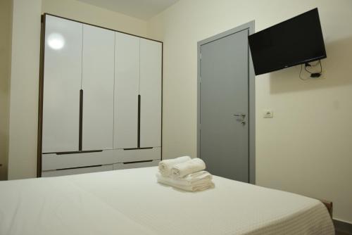 a bedroom with a bed with a mirror and towels at Residence Rudaj in Vlorë