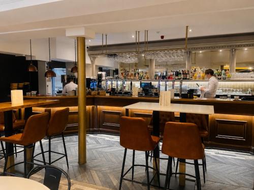 a restaurant with tables and a chef preparing food at The Psalter in Sheffield