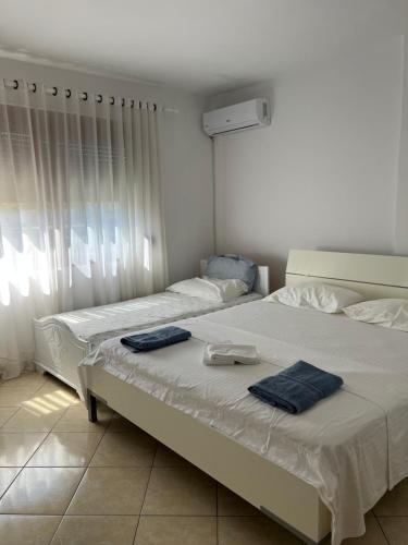 two beds in a bedroom with towels on them at Grediv Apartment Orikum in Orikum