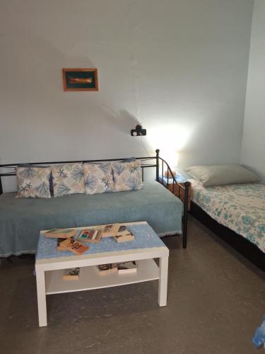 a room with two beds and a coffee table at La casa di lefki in Elafonisos