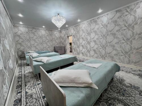 a row of four beds in a room at Archa Ethno Guest House in Bokonbayevo