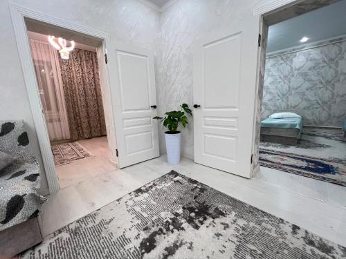 a room with two white doors and a potted plant at Archa Ethno Guest House in Bokonbayevo