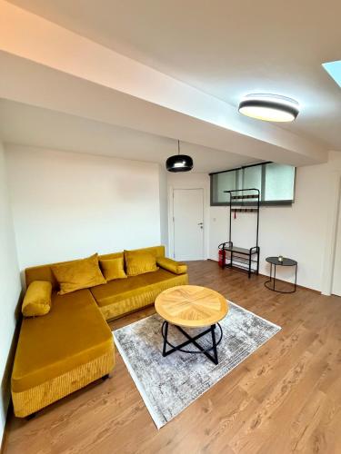 a living room with a yellow couch and a table at COSMOS Panorama Apartments in Prilep