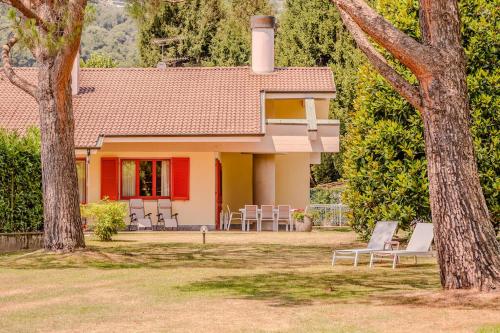 a house with chairs and a house with a tree at Villa Lago Maggiore in Lesa