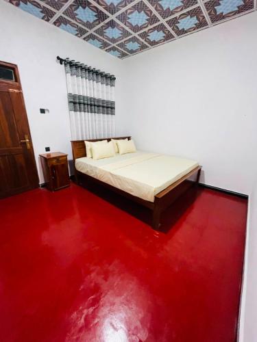 a bedroom with a bed and a red floor at Green Haven - Wilpattu in Wilpattu