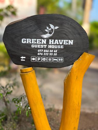 a sign for a greenhaven guest house on a wooden stand at Green Haven - Wilpattu in Wilpattu
