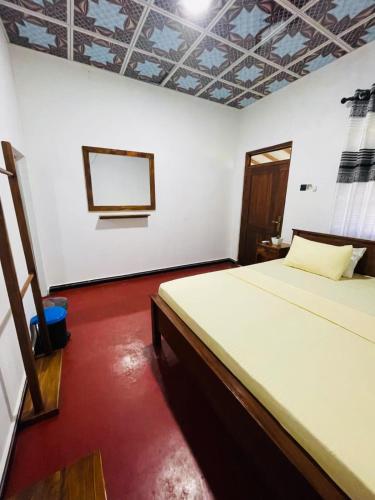 a bedroom with a bed and a white wall at Green Haven - Wilpattu in Wilpattu
