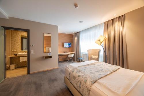 a hotel room with a bed and a desk at Berliner Hof Bed&Bike in Saint-Vith