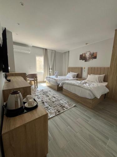 a hotel room with two beds and a television at Saqqara Pyramids view Hotel in Cairo
