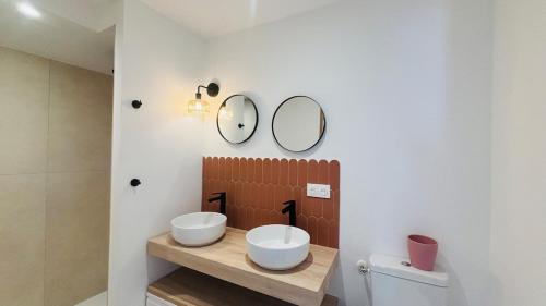 a bathroom with two sinks and a mirror on the wall at Appartement arche centre historique in Narbonne