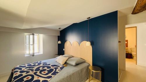 a bedroom with a bed with a blue wall at Appartement arche centre historique in Narbonne