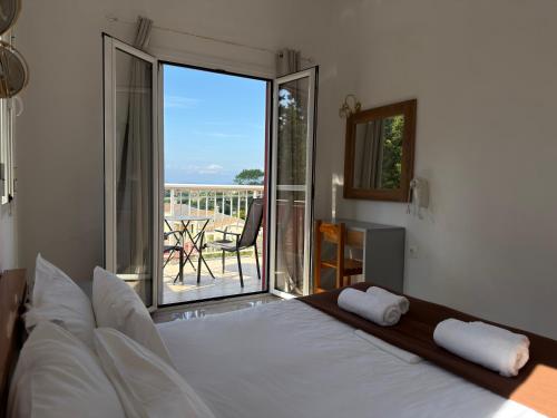 a bedroom with a bed and a balcony with a view at Mediterranean Blue in Kavos