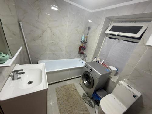 a bathroom with a sink and a toilet and a tub at NurNomad 2 in Balykchy