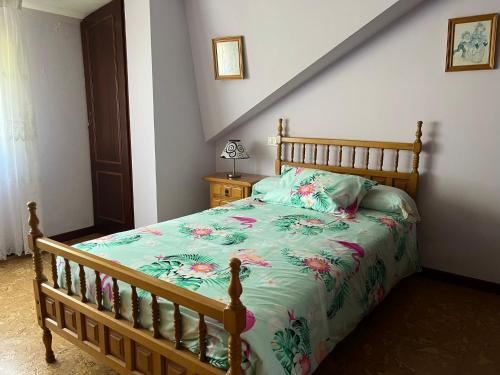 a bedroom with a bed with a floral bedspread at Casa Ezaro in Dumbría