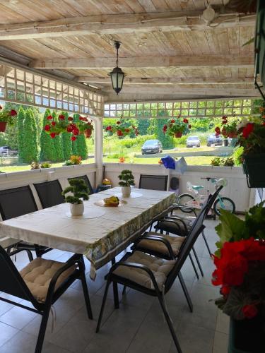 a dining room with a table and chairs and flowers at Kuća JEKA in Vrnjačka Banja