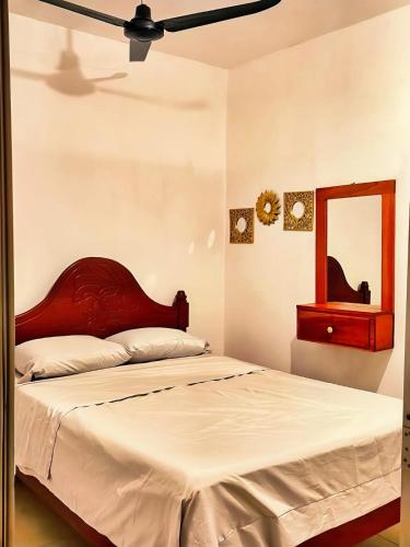 a bedroom with a bed with a red headboard and a mirror at Departamento Refugio Verde in Palenque