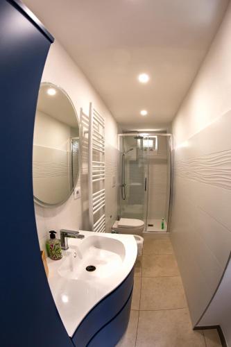 a white bathroom with a sink and a mirror at A Casa di Gaia 2 in San Benedetto