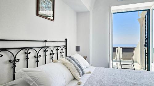 a bedroom with a bed with a view of the ocean at Al Poggio Antico in Amalfi