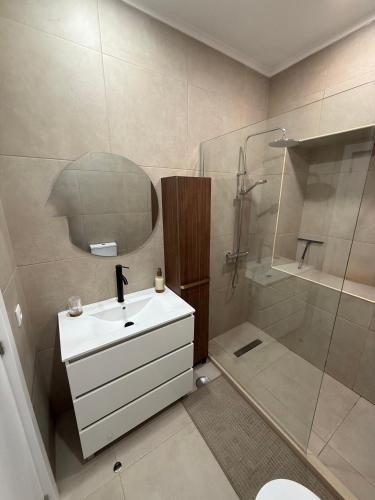 a bathroom with a sink and a shower and a mirror at Casa Vila de Frades in Vila de Frades