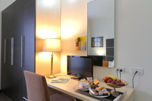 a desk with a computer and a bowl of fruit on it at Hotel Ferrari in Chiavari