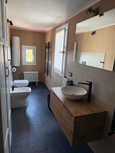 a bathroom with two sinks and a large mirror at Villa Gopal Natura Toscana vicino Lucca 7 posti in Capannori