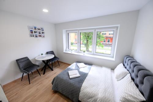 a bedroom with a bed and a table and a window at NOVA Apartment - 1 in Klaipėda
